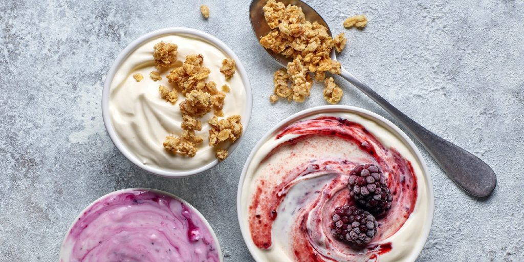 bowls of various greek yogurt on kitchen table, top view