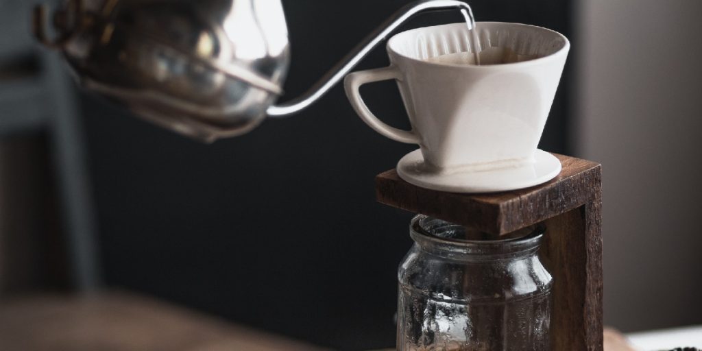 coffee In a glass bottle,Coffee drip,Hand holding a kettle Drip Coffee In the room