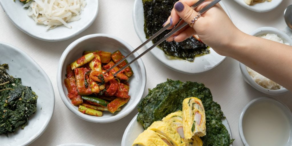 Woman with Chopsticks Getting Cucumber Kimchi