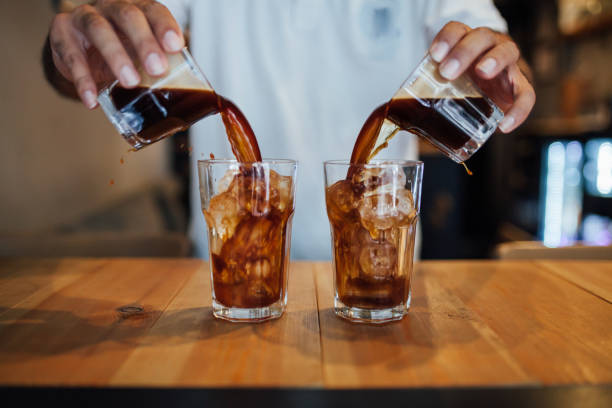 gentleman pouring two cold brew coffees into glasses. Coffee was made with a cold brew infuser